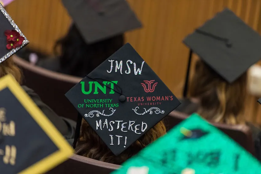 A graduate cap decorated with both university logos and 