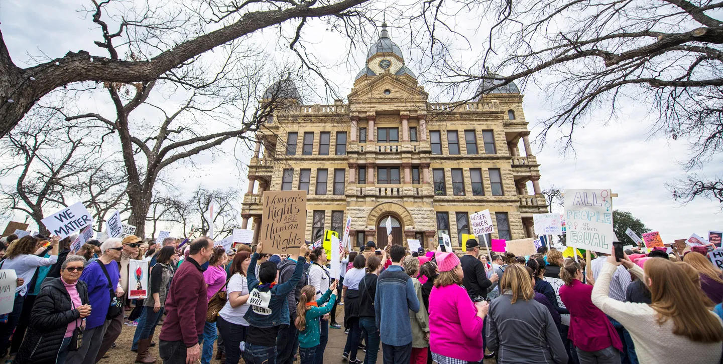 Citizens marching with signs at the Denton Women's March