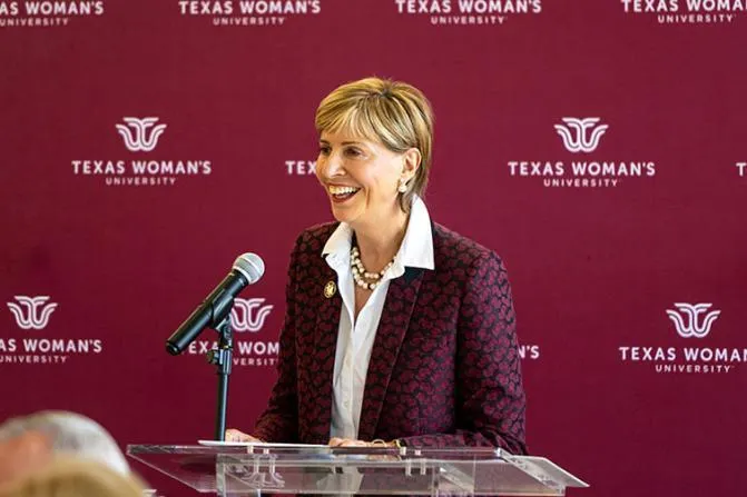 Chancellor Feyten speaks at a podium with a TWU logo backdrop
