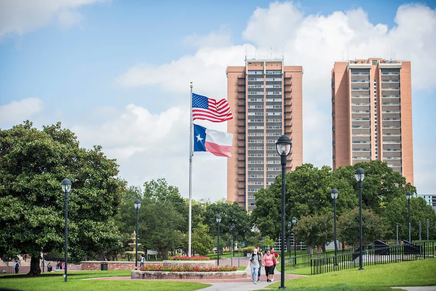 The American and Texas flags fly in front of the dorms on TWU's Denton campus.