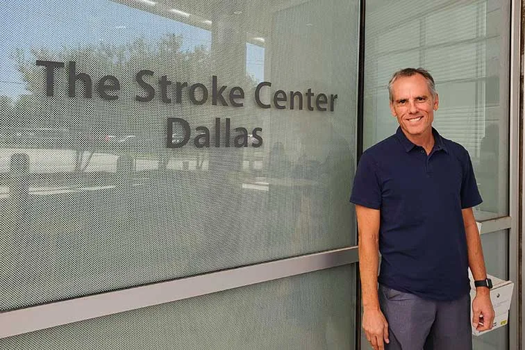 man stands in front of window with The Stroke Center Dallas written on it
