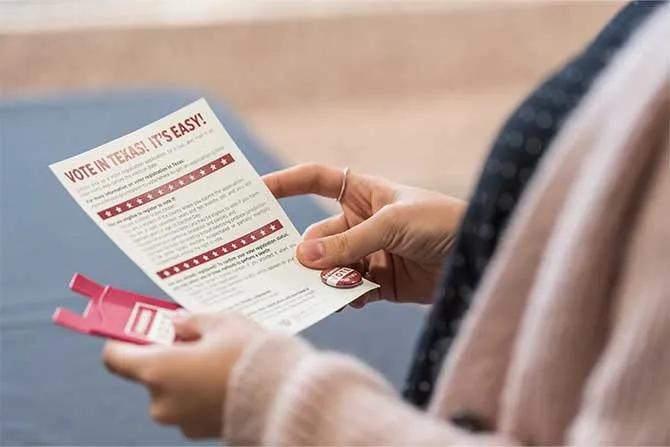 TWU student holding card with voting information