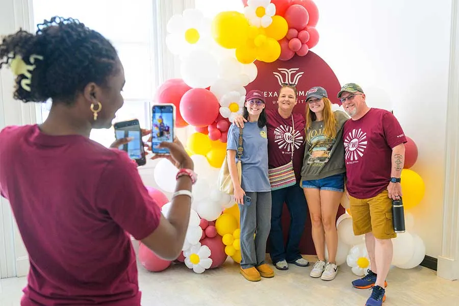 TWU Family posing in front of balloons 