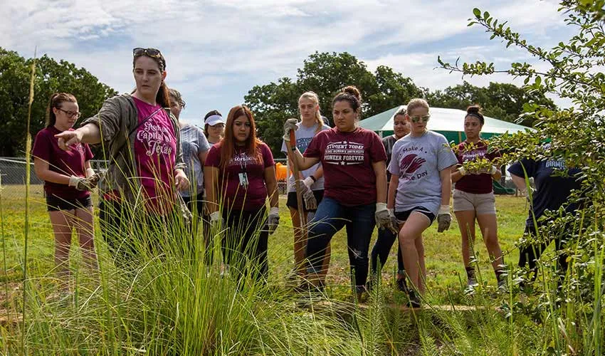 TWU students volunteering at city of Denton garden. 