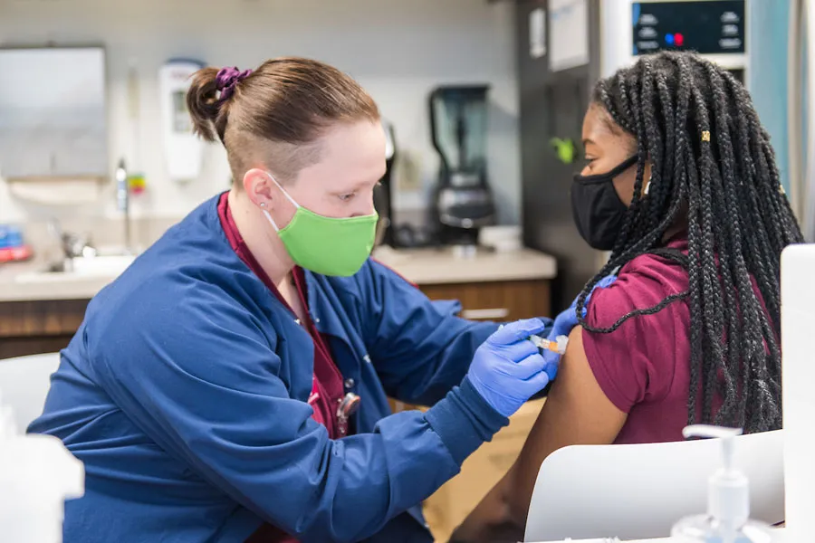 TWU SHS worker administering a shot