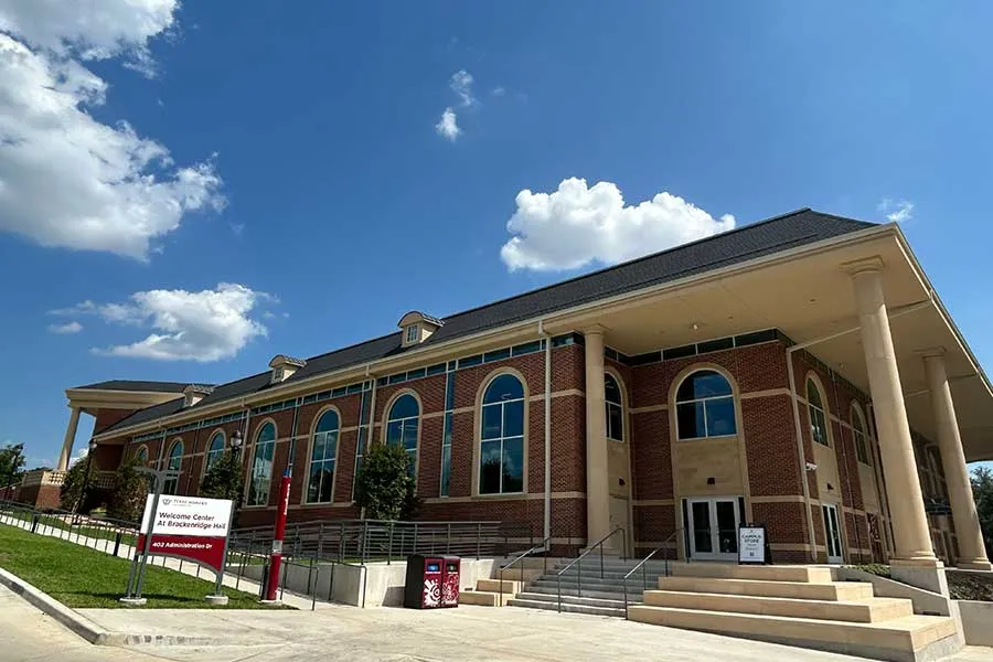 Exterior of Brackenridge Hall on a sunny day with blue sky in the background