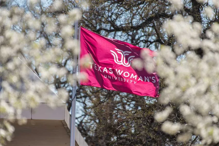 TWU flag surrounded by Bradford pear blooms