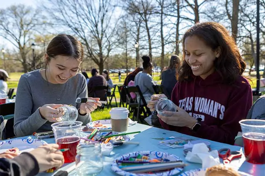 TWU students painting plant jars at the Garden Party event