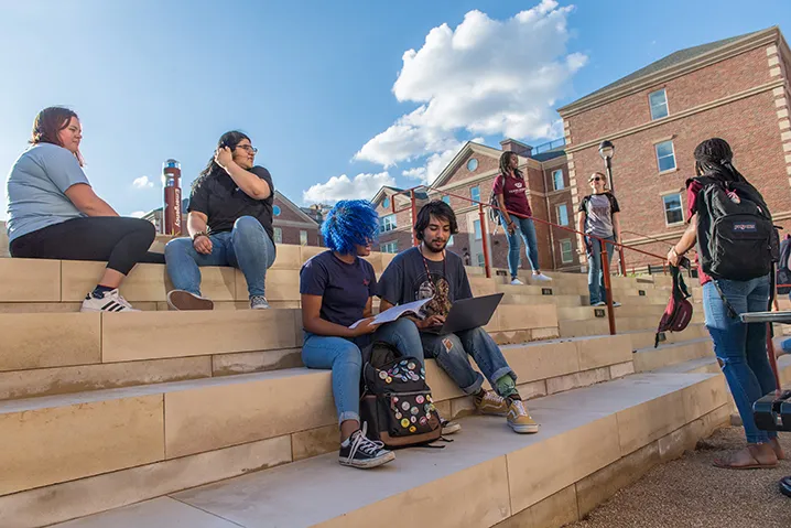 students sitting on steps looking at a computer