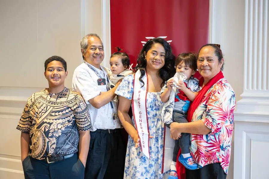 A TWU first-generation student receives her stole and poses with her family at the ceremony reception.