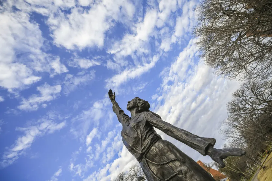 Statue of a girl reaching to the sky on TWU's Denton campus.