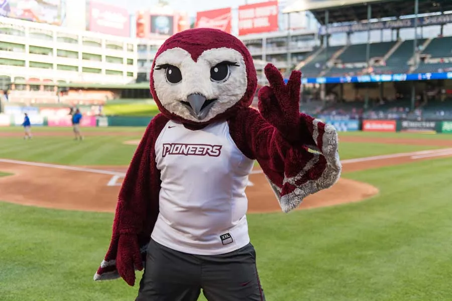 Oakley makes the TWU hand sign on the field at the Texas Ranger's stadium.