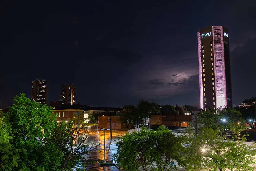 The TWU skyline lit up at night with the ACT Tower lights on.