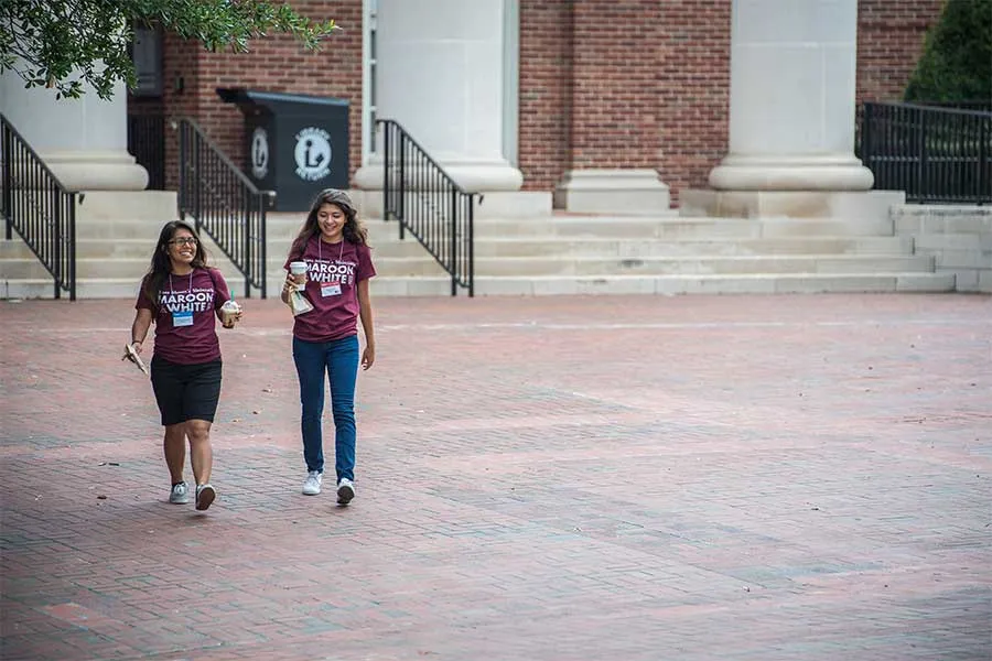 Two TWU students leave the library on the Denton campus.