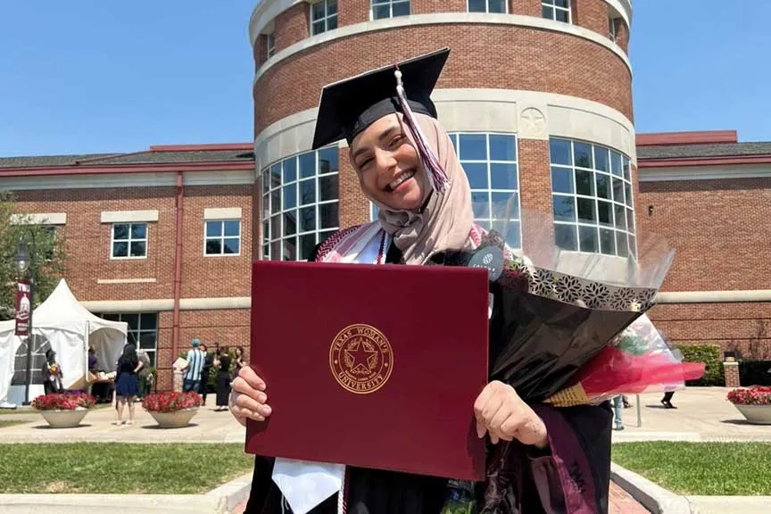 A ��ݮ��ý�������� student holding a diploma