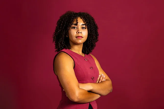 A portrait of a TWU student on a maroon background.