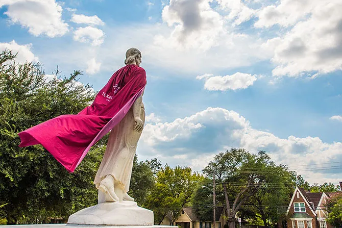 Minerva statue with a cape on that is blowing in the wind.