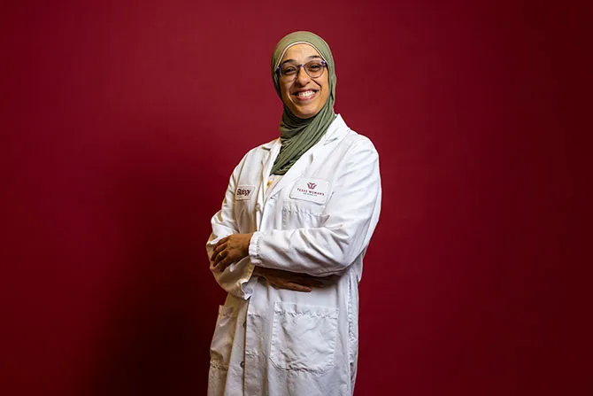 A portrait of a TWU Biology graduate student in a labcoat.