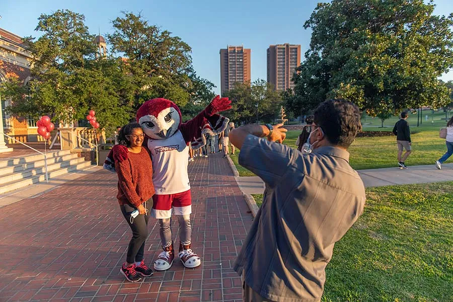A prospective TWU student poses for a photo with mascot Oakley