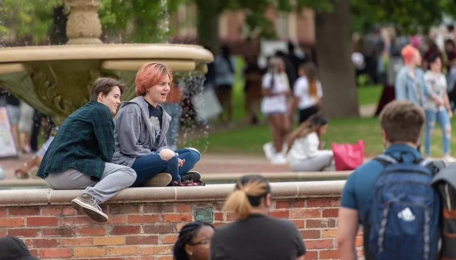 TWU students hang out by the fountain on the Denton campus