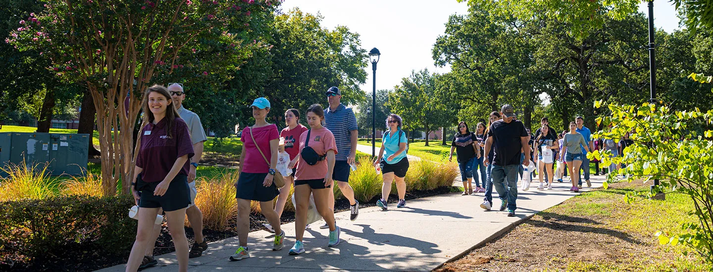A group of tour attendees follow a Pioneer Ambassador on the Denton campus.