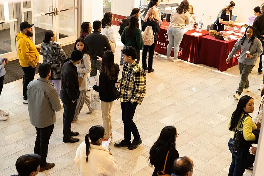 Potential students and their families gather in the lobby of the Houston Center before beginning a campus tour