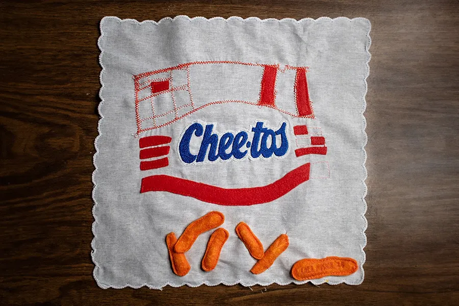 Vintage napkin features hand embroidered Cheetos logo and appliqué cheetos