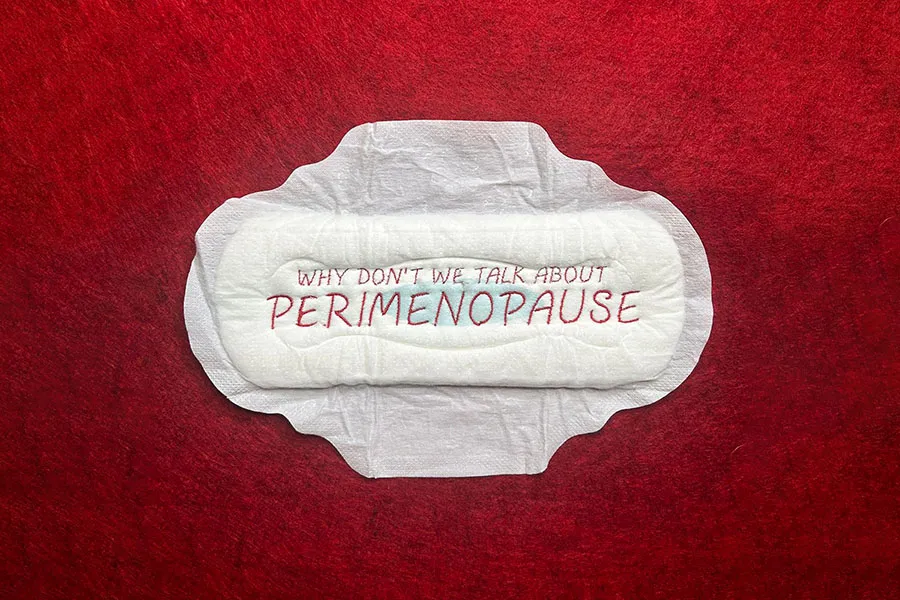 Embroidered sanitary napkin on red background. Text reads, 