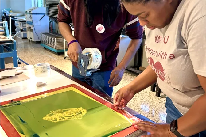 Students tape off silkscreen during AIGA.TWU workshop