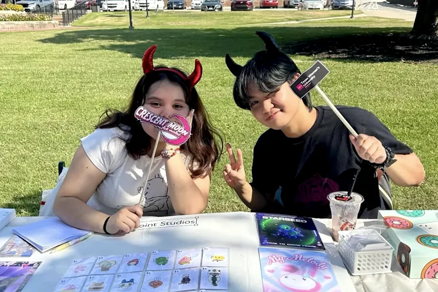 Students from AIGA table at the Crescent Market, a student led art-market on campus,
