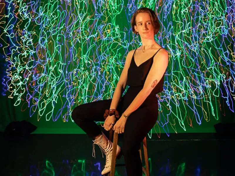Student poses on stool during Light Painting Workshop led by PAC