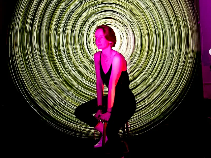 Student poses on stool during Light Painting Workshop led by PAC