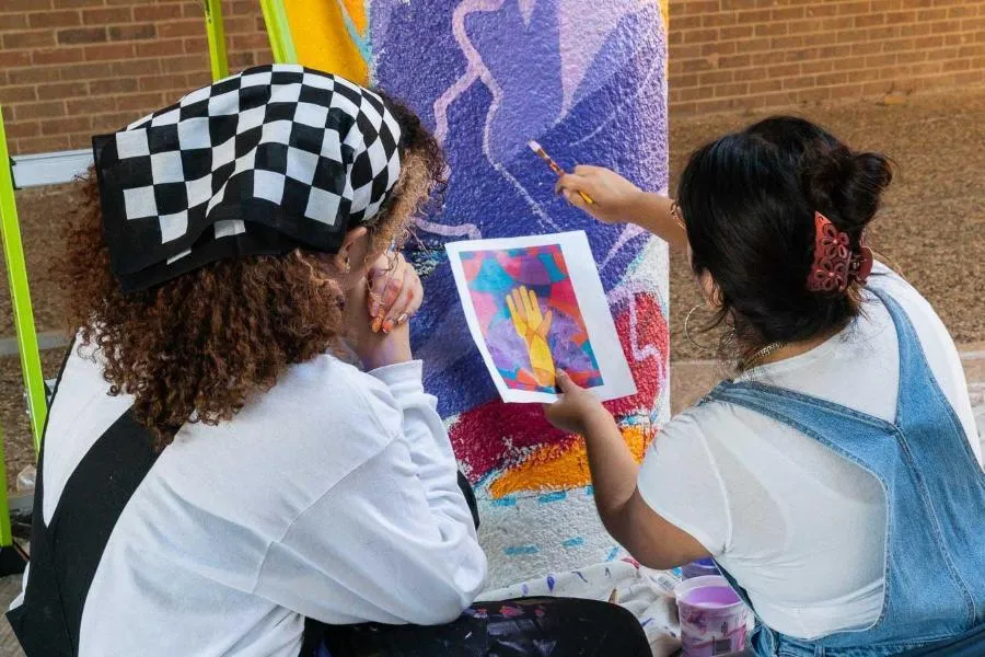 Students work on a recent campus mural.