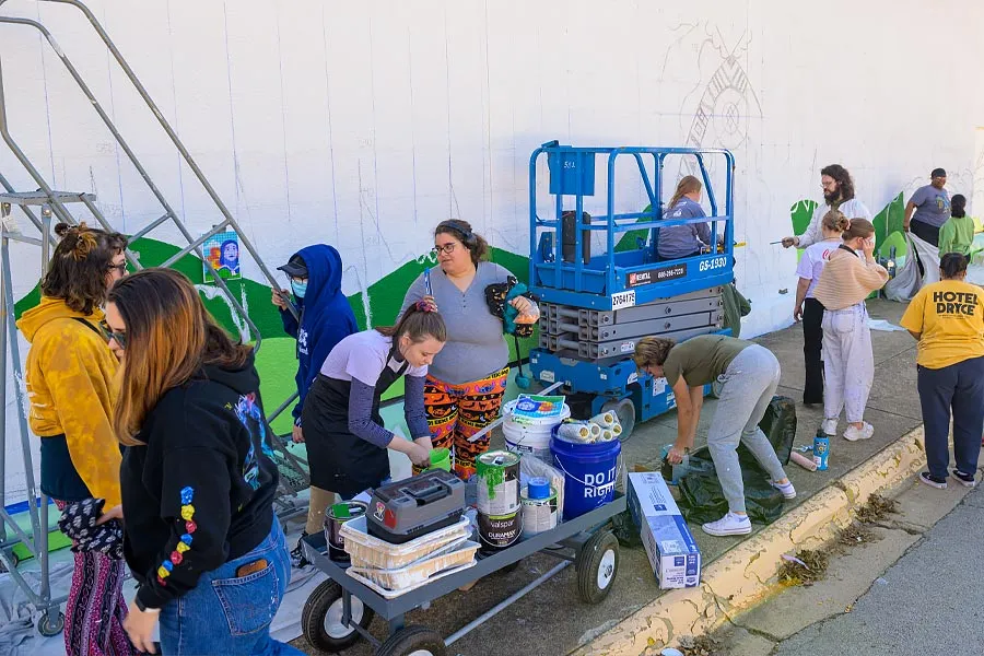 A group of students work on a mural 