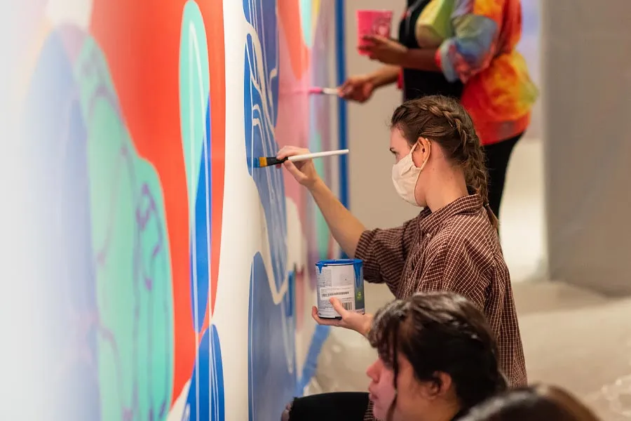 Students paint the mural in the Student Union