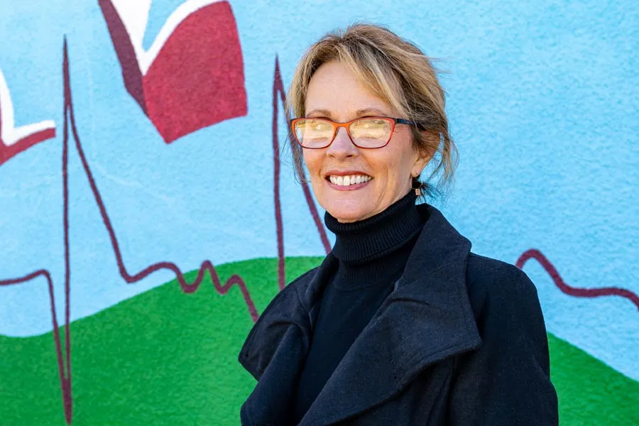 Diane Cox in front of the mural she designed