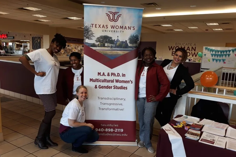 Planning committee members Foluso Oluade, Morgan May, Marcella Clinard, Esther Ajayi-Lowo, and Chelle Wilson, all MWGS graduate students, pose with their department’s banner at the reproductive justice fair.