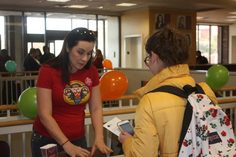 A local midwife discusses reproductive health with a TWU student at the reproductive justice fair.