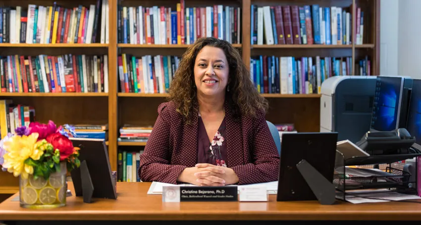 Photo of Christina Bejarano, PhD, sitting at her office desk 
