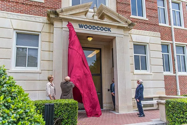 The unveiling of the Woodcock Hall name over the front of the building