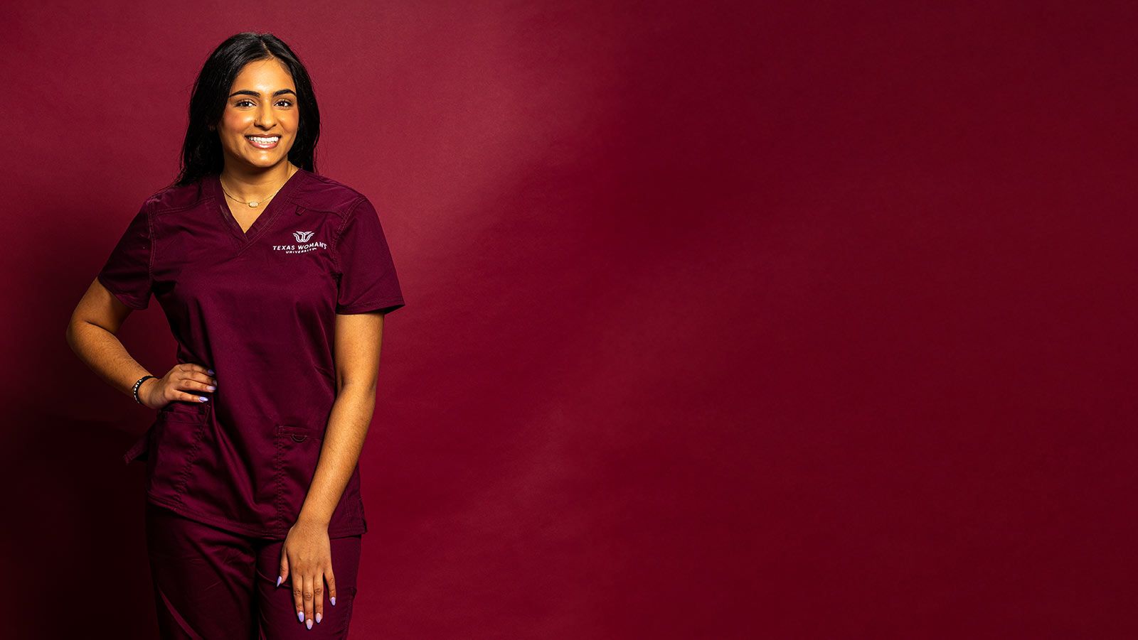 TWU Nursing student wearing maroon scrubs